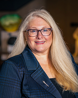 Amy-Web-Sm Commissioner Chudzinsk smiles at the camera. She wears glasses and a blue, plaid suit.